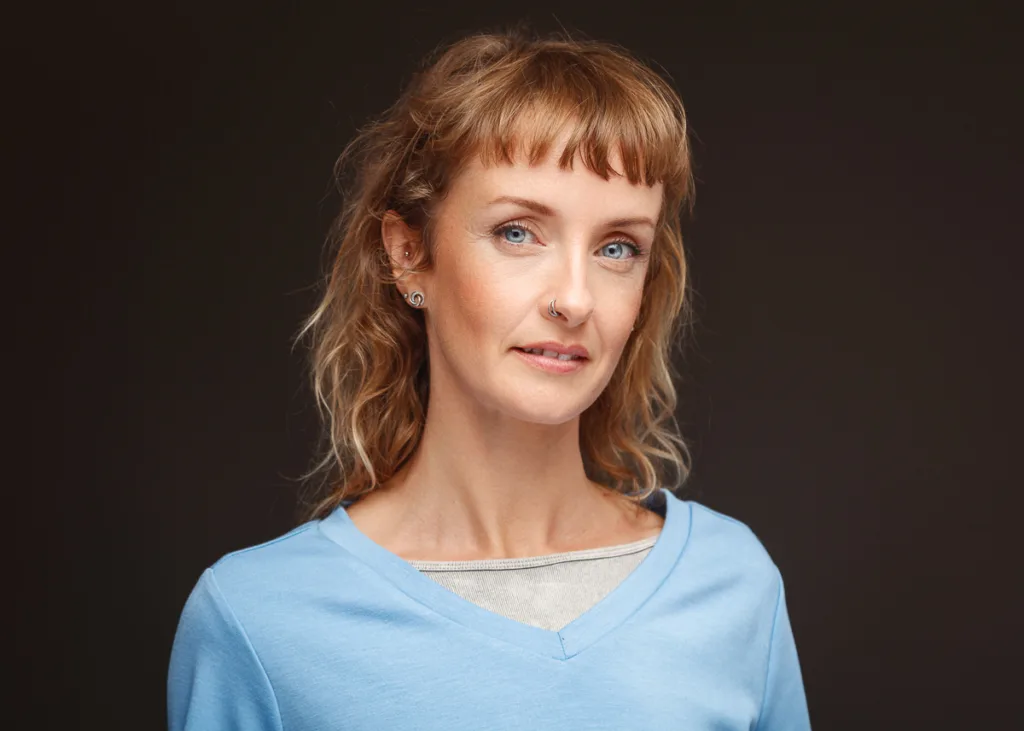 Smiling woman with piercings and blue top