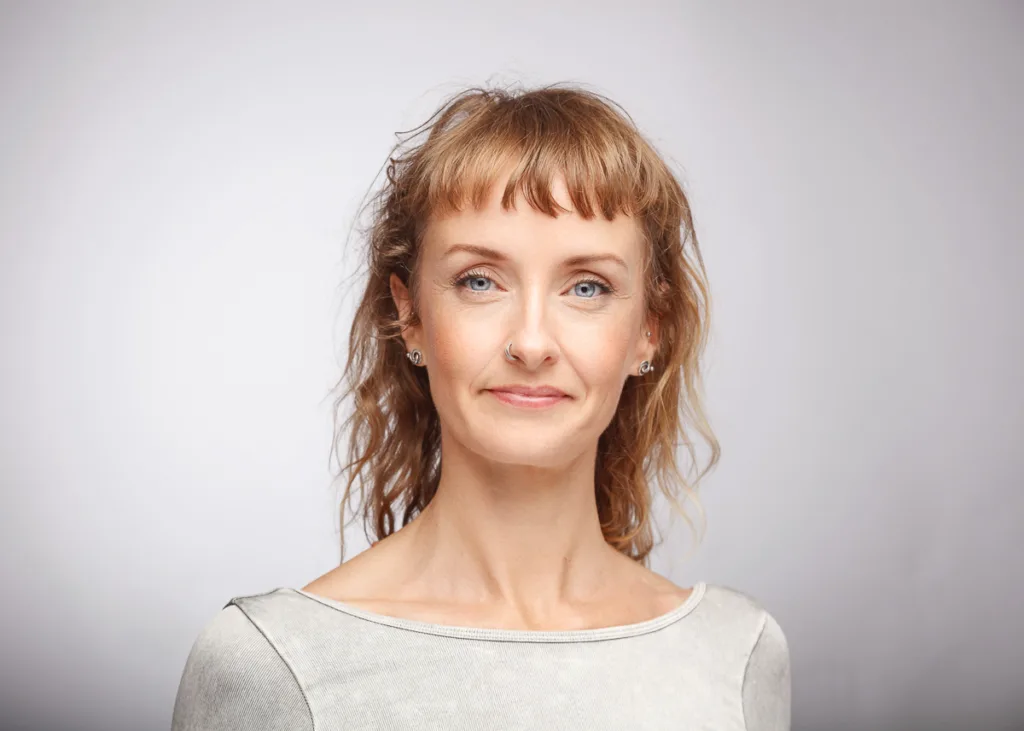 Woman with short brown hair poses confidently