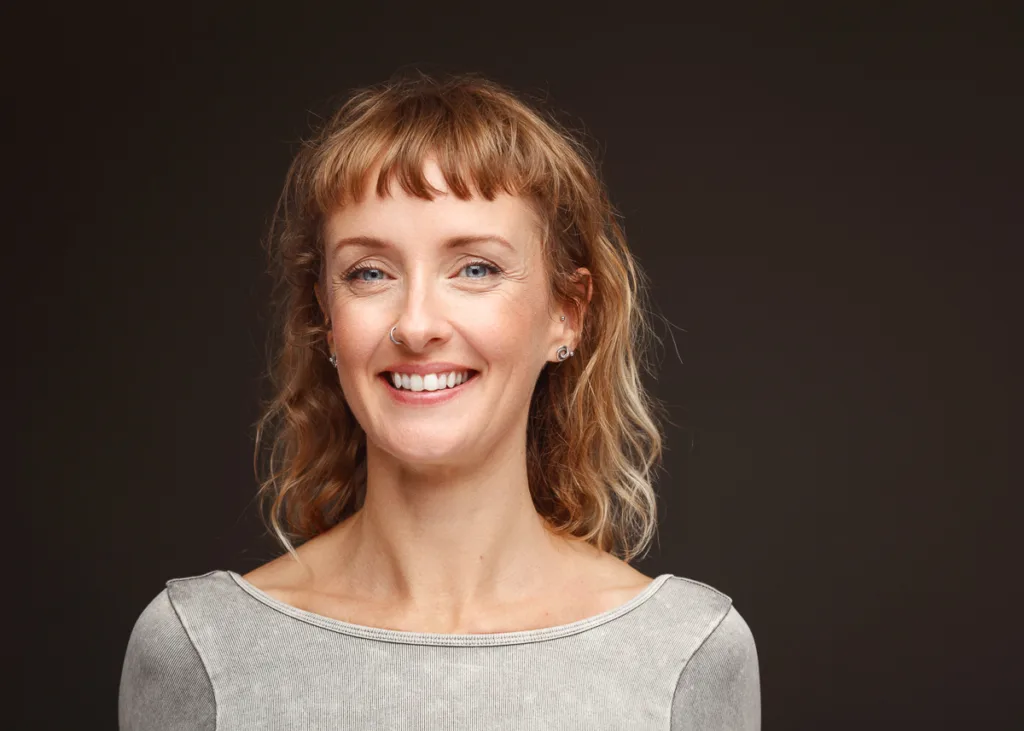 Woman smiling against dark background