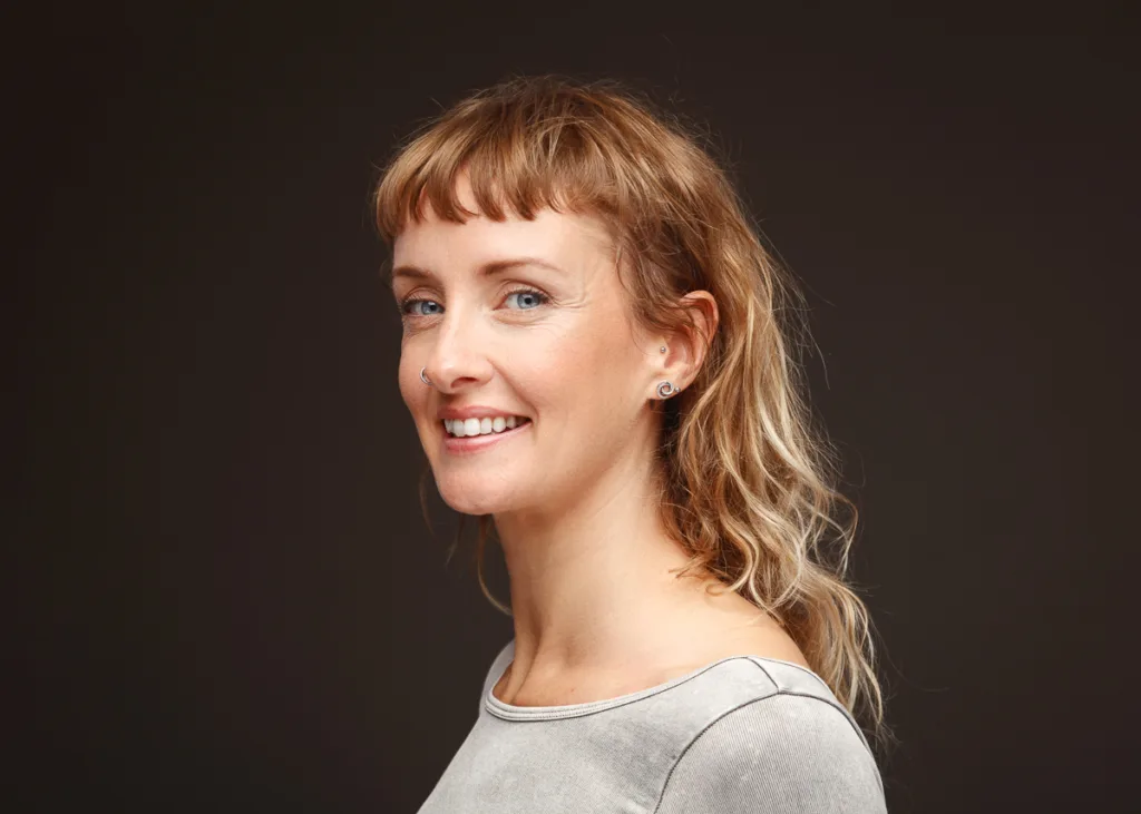 Smiling woman with earrings and light brown hair