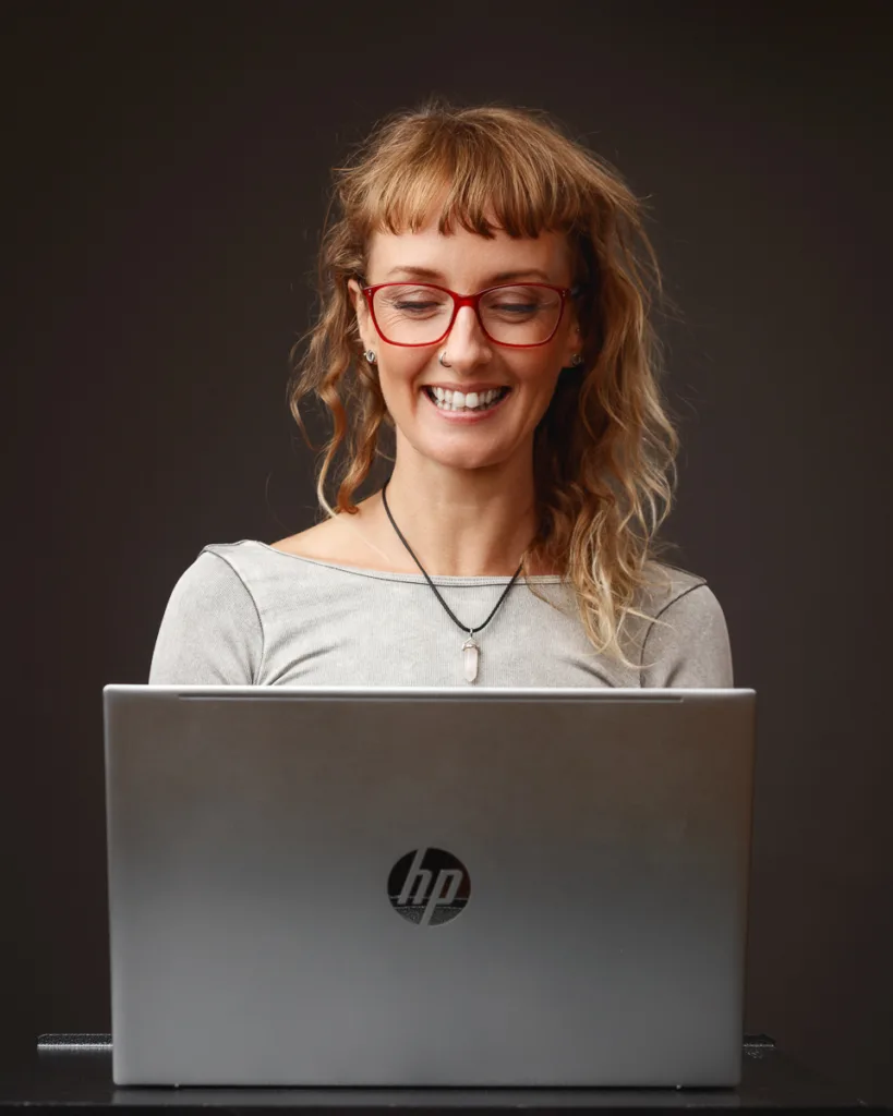 Smiling person using an HP laptop.