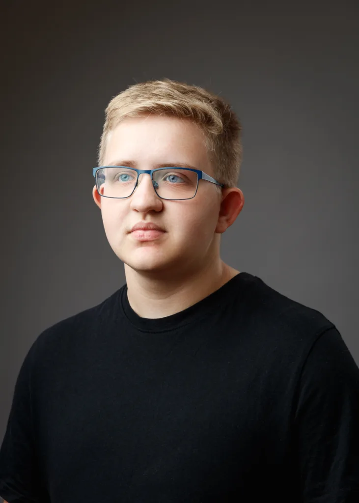 Person in glasses and black t-shirt.