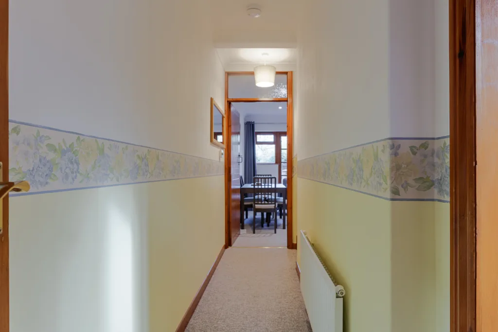 Narrow hallway leading to a dining room.