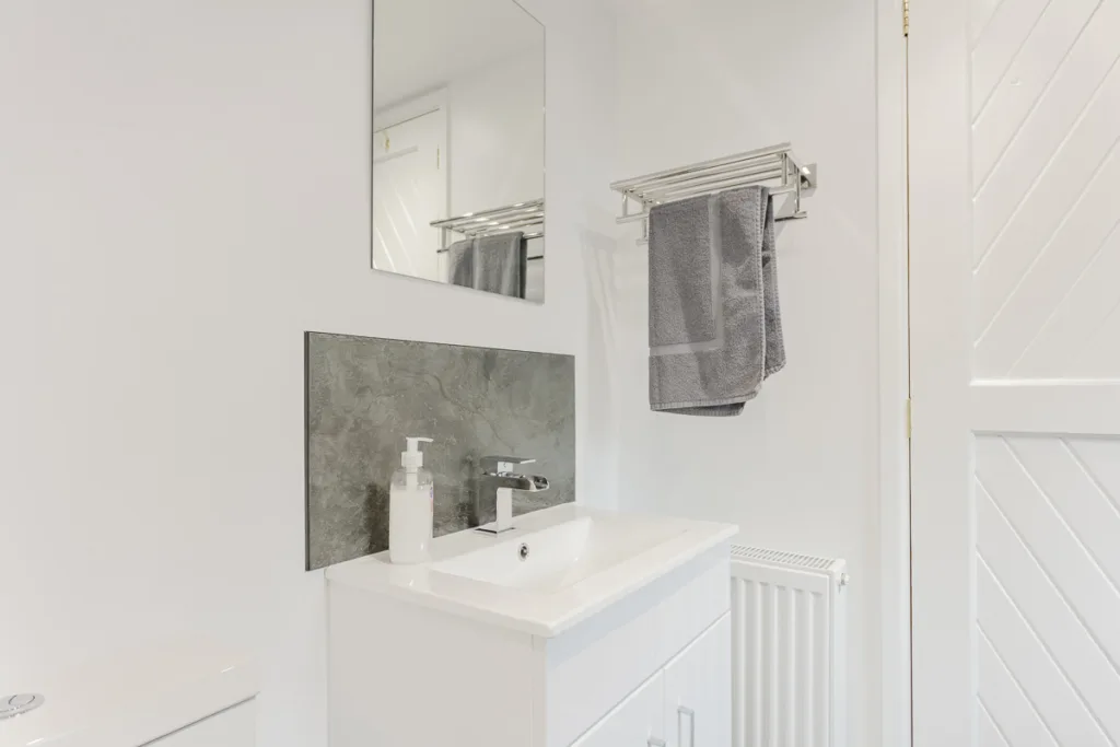 Modern bathroom with sink and towel rack.