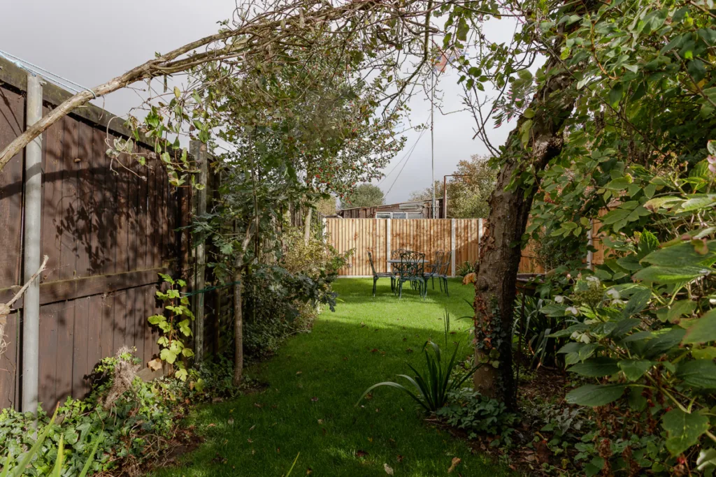 Garden with patio furniture set under trees.