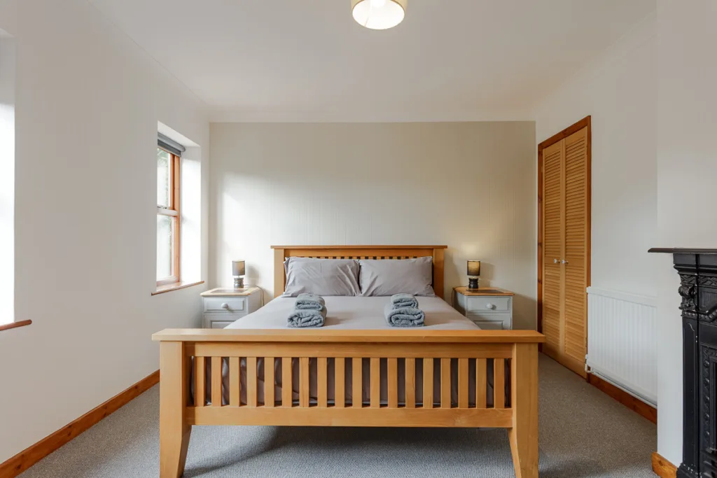 Cosy bedroom with wooden bed and bedside tables.