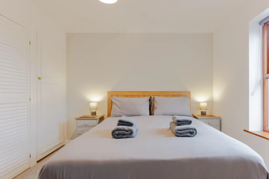 Cosy bedroom with double bed and bedside lamps.