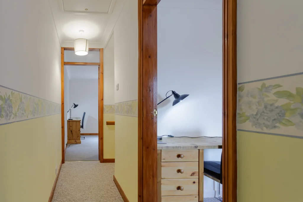 Hallway leading to a desk with lamp.