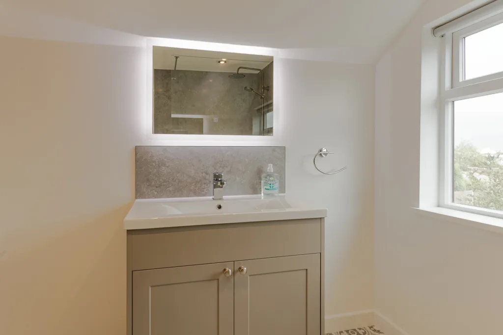 Modern bathroom vanity with illuminated mirror.