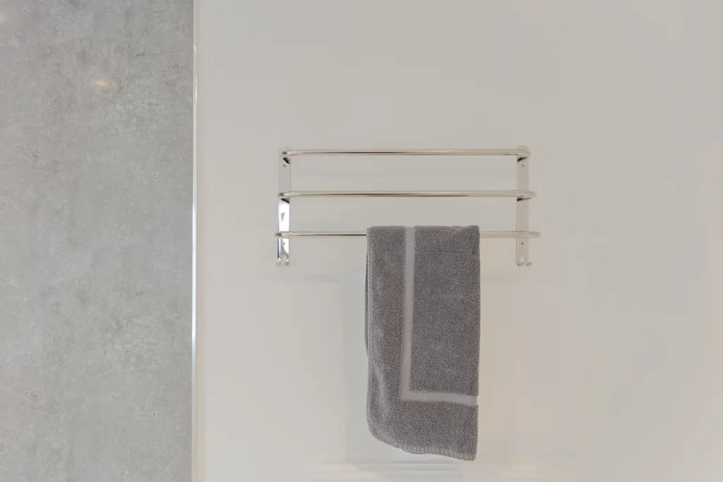 Grey towel hanging on chrome towel rack.