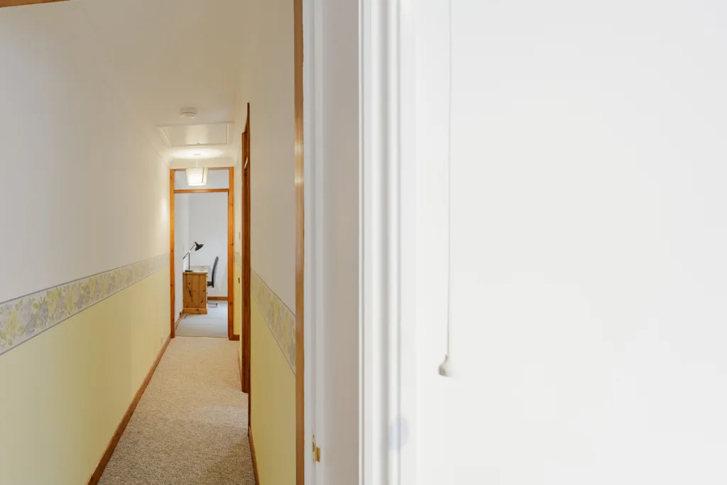 Narrow hallway leading to a study room