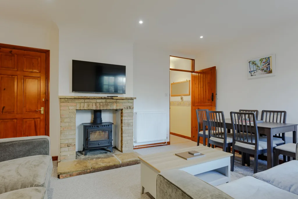 Modern living room with fireplace and dining table.
