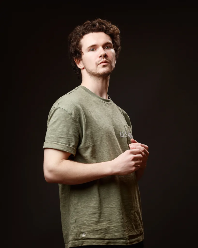 Person wearing a green T-shirt, neutral background.