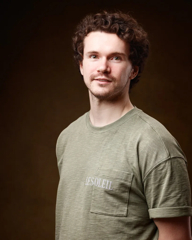 Person in green shirt with curly hair smiling