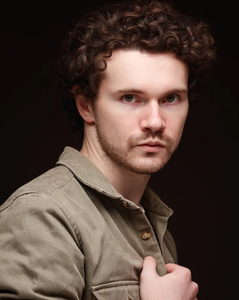 Man with curly hair in neutral jacket