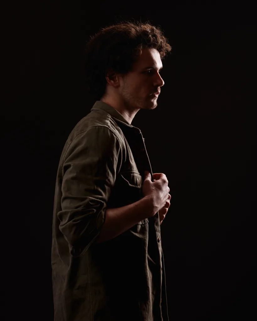 Silhouette of man in a dark shirt, side profile.