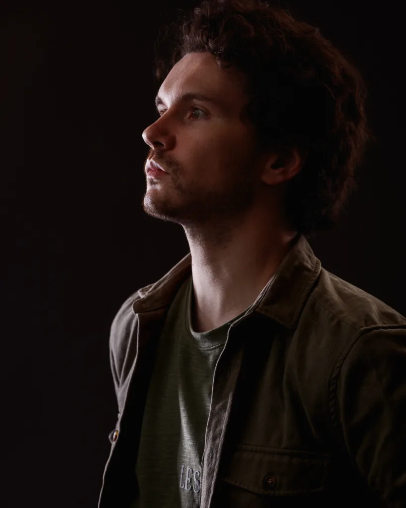 Man gazing upwards, wearing green jacket