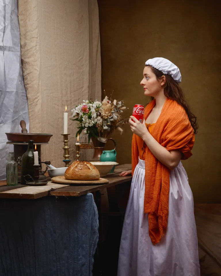 Woman in historical dress holding a Coca-Cola can.