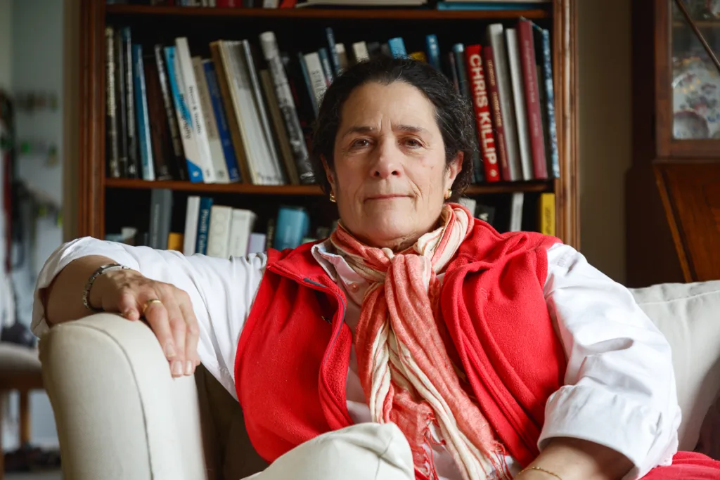 Person sitting on sofa, books in background