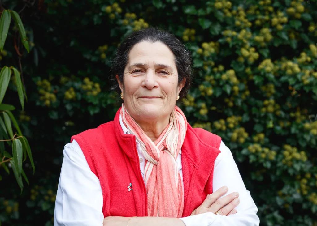Person in red vest with crossed arms outdoors