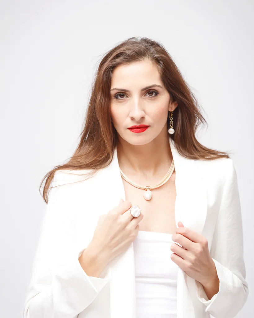 Woman in white blazer with red lipstick.