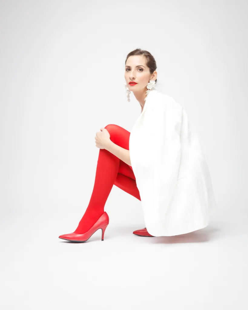 Woman in white with red tights and heels.