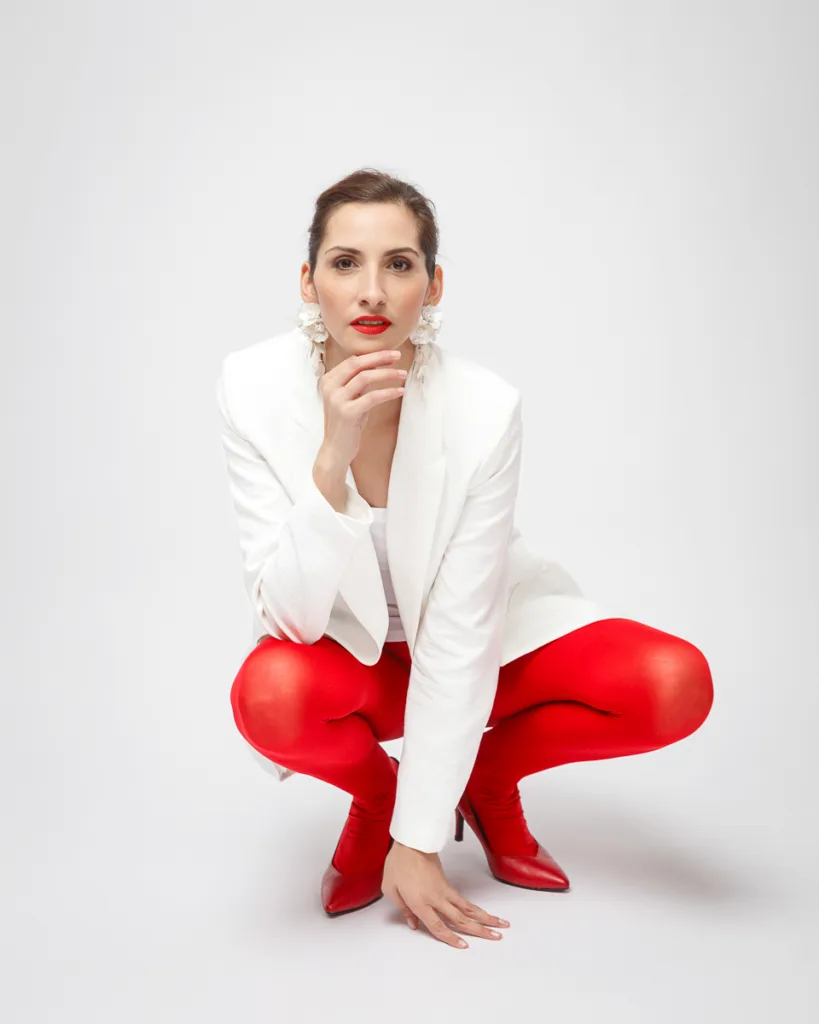 Woman in red tights and white blazer posing