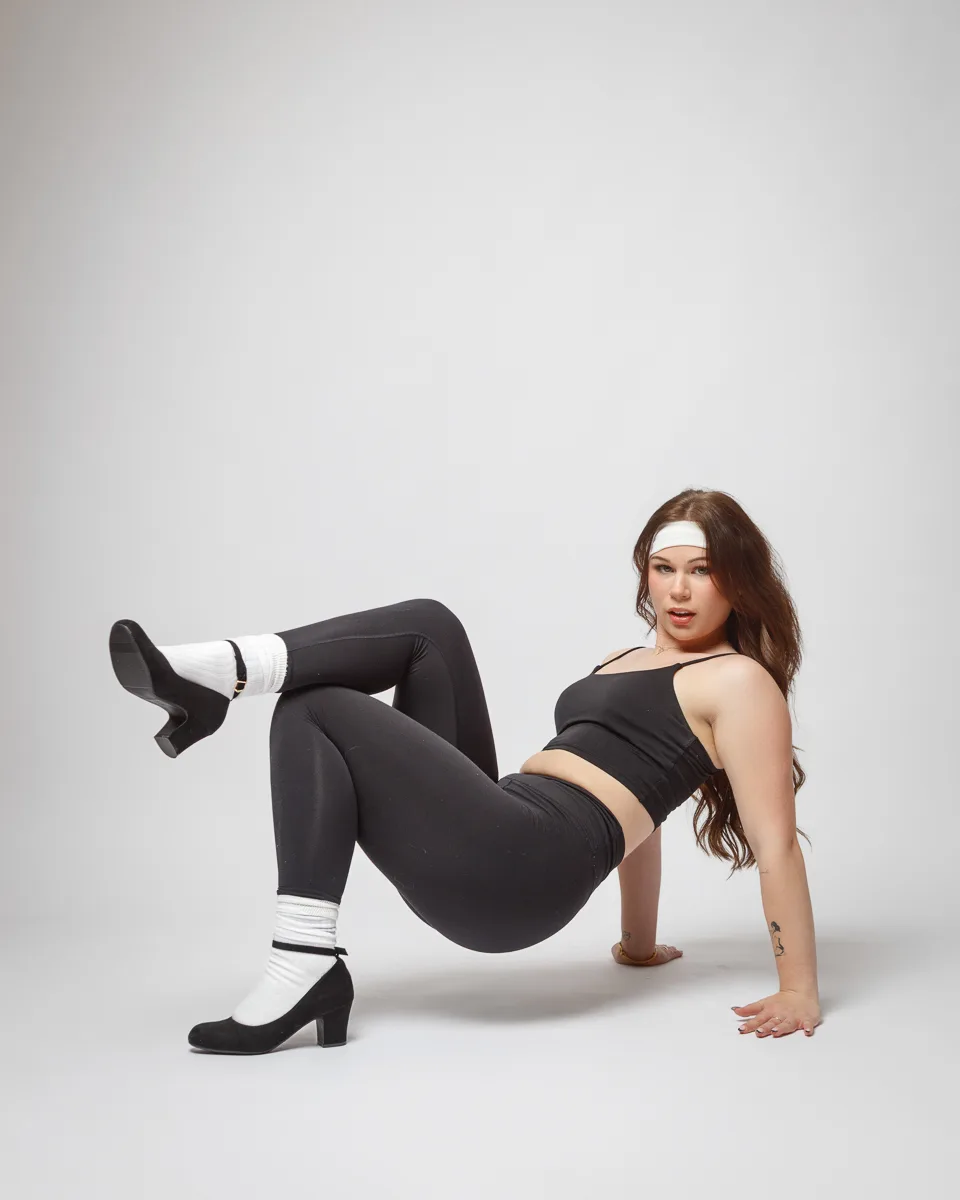 Person posing in activewear and heels.