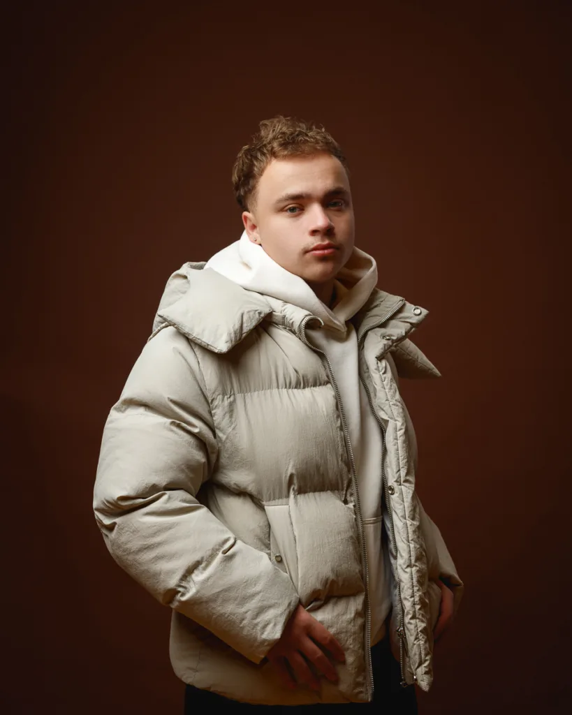 Person wearing beige puffer jacket and hoodie.