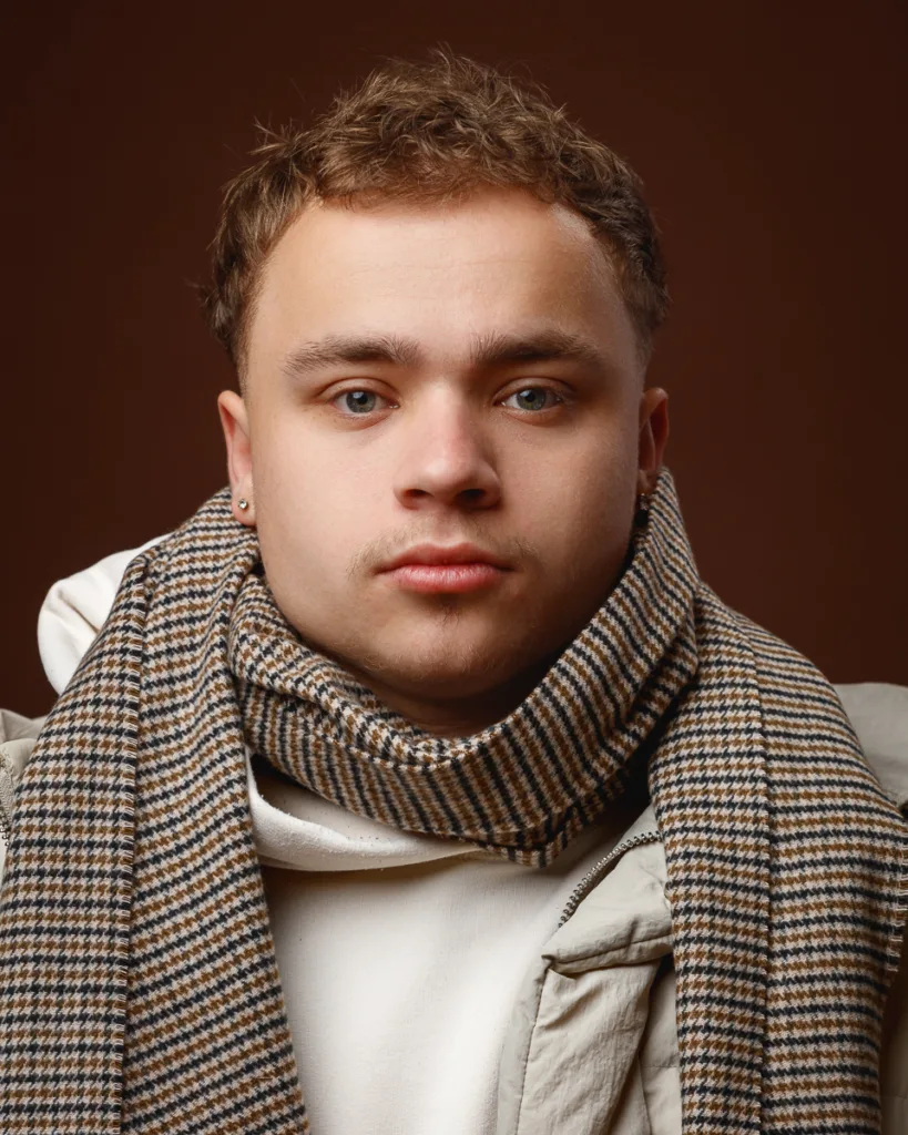 Person wearing a checked scarf and white jacket.