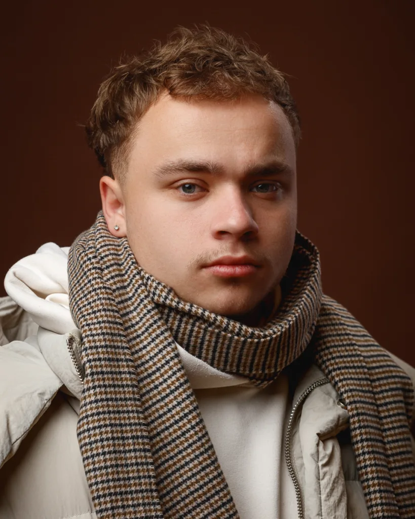 Person wearing striped scarf and white jacket