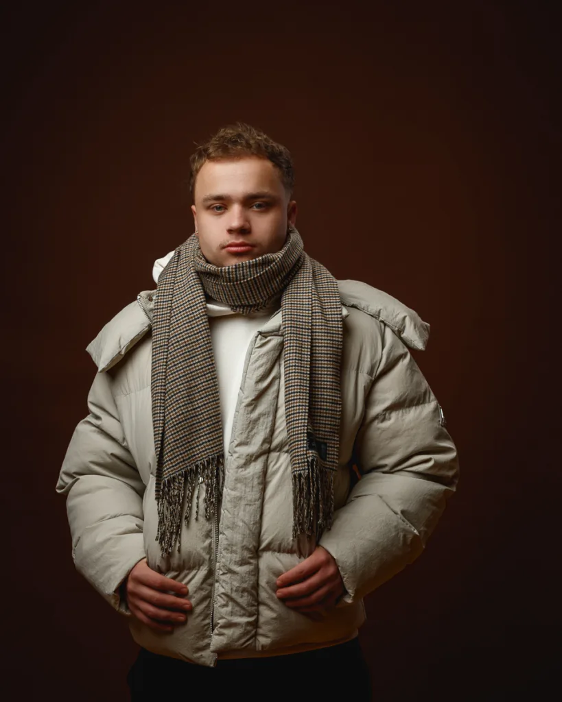 Person wearing winter coat and checkered scarf.