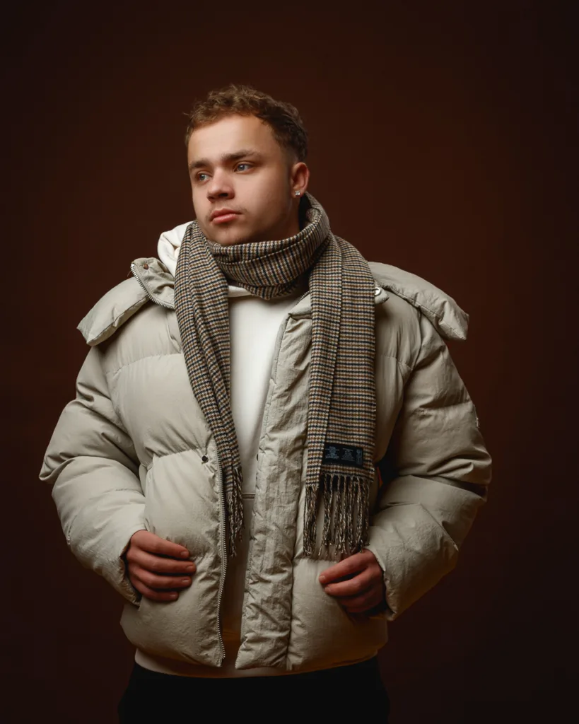 Person in puffer jacket and checkered scarf