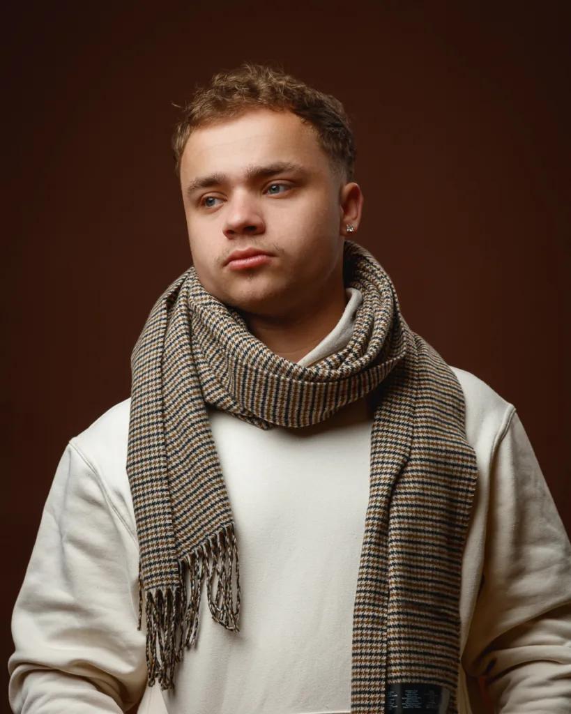 Person wearing checked scarf and white sweatshirt.