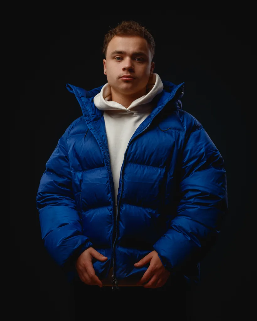 Person in blue puffer jacket and white hoodie.