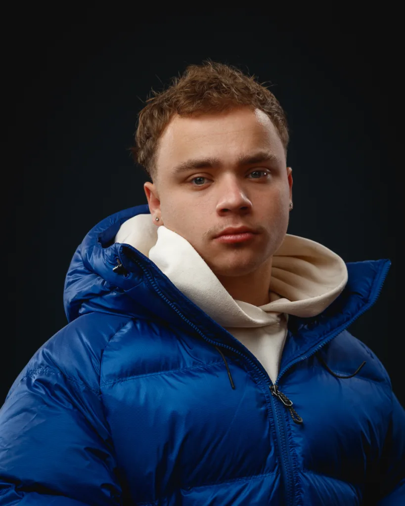 Person wearing blue jacket and white hoodie.
