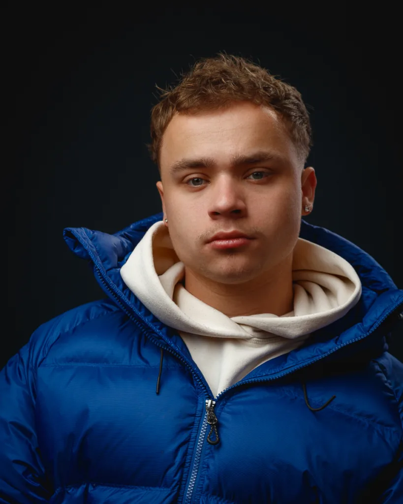 Person in blue jacket with white hoodie.