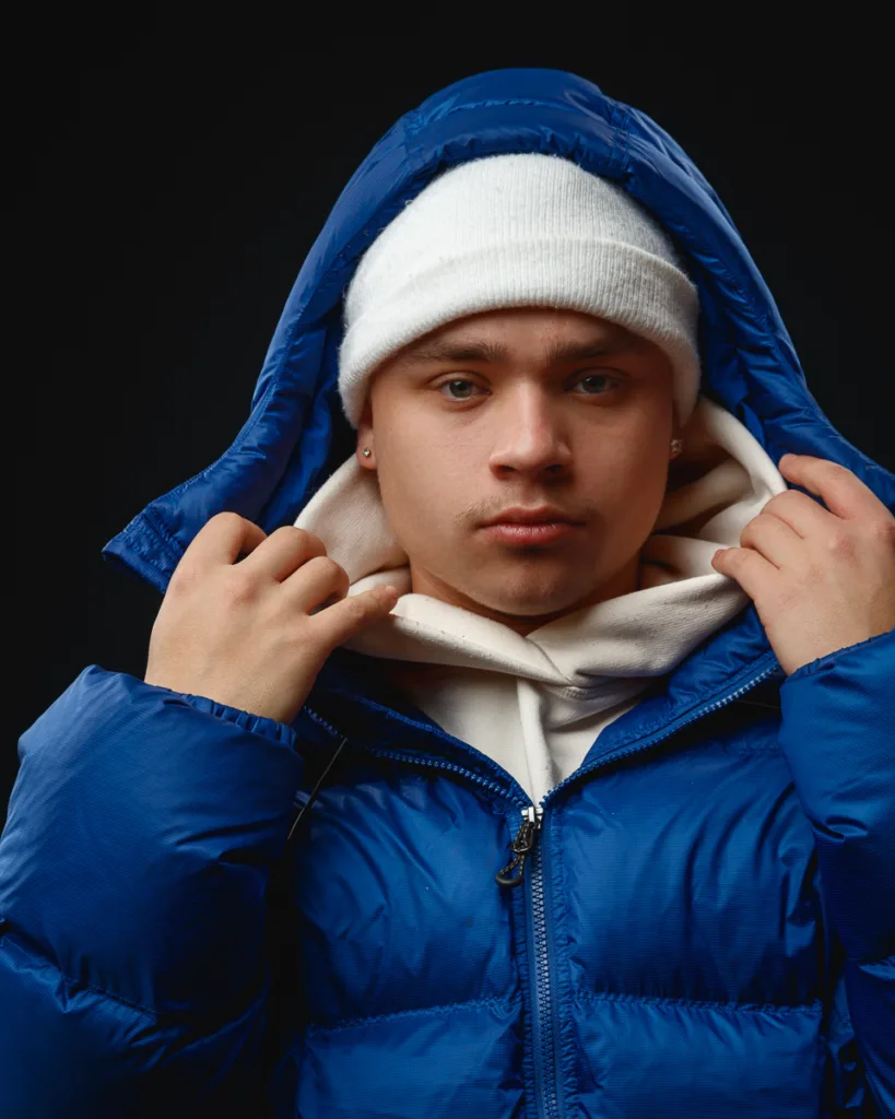 Person in blue jacket and white beanie.