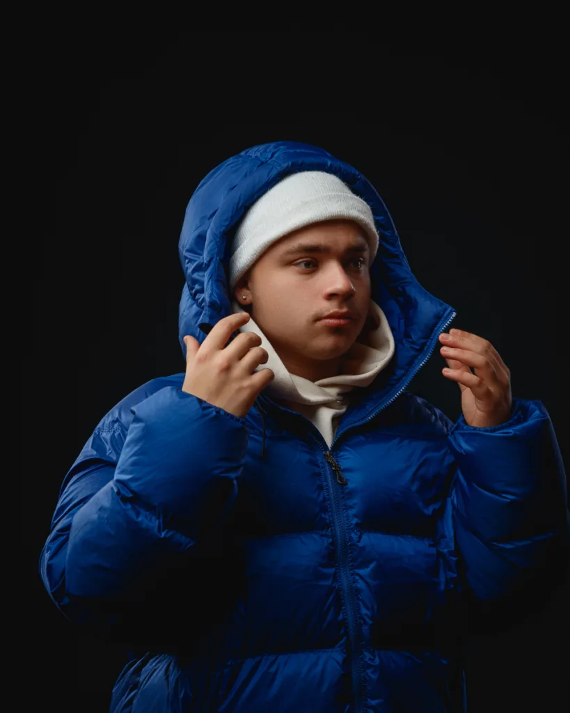 Person in blue jacket and white beanie.