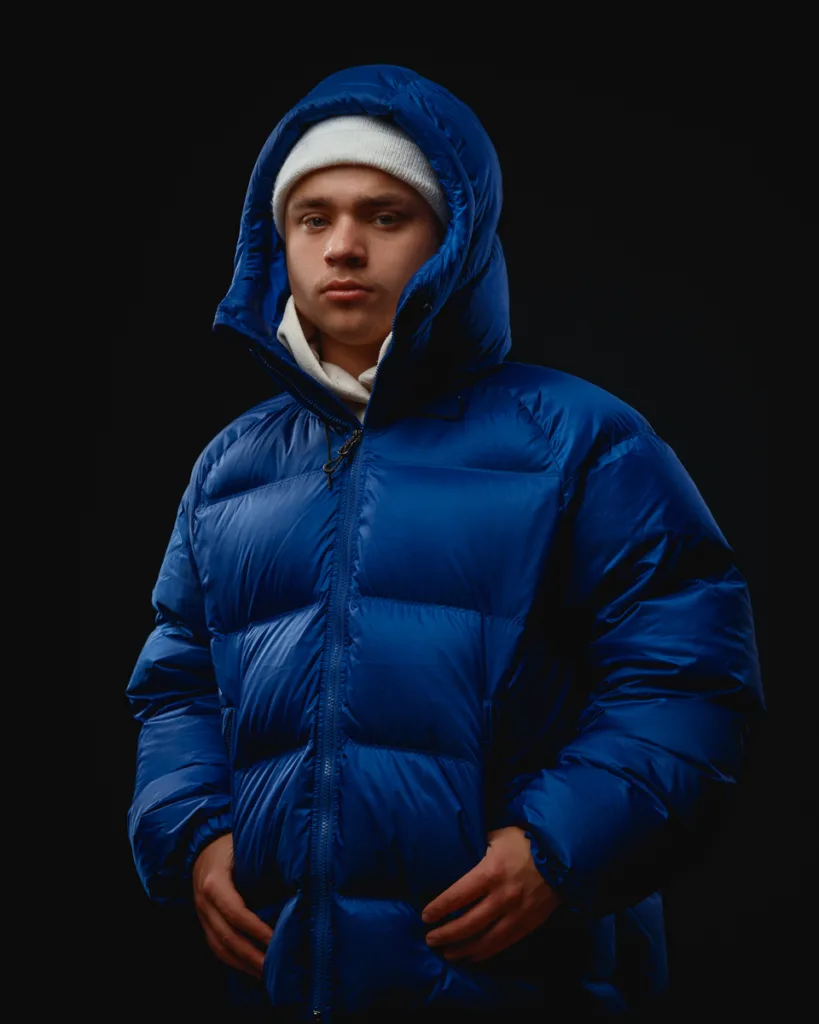 Person in blue puffer jacket and white beanie.