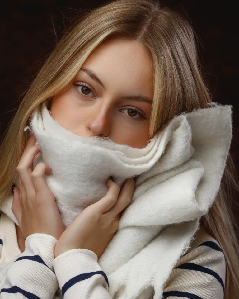 Person with white scarf covering face, blonde hair visible.