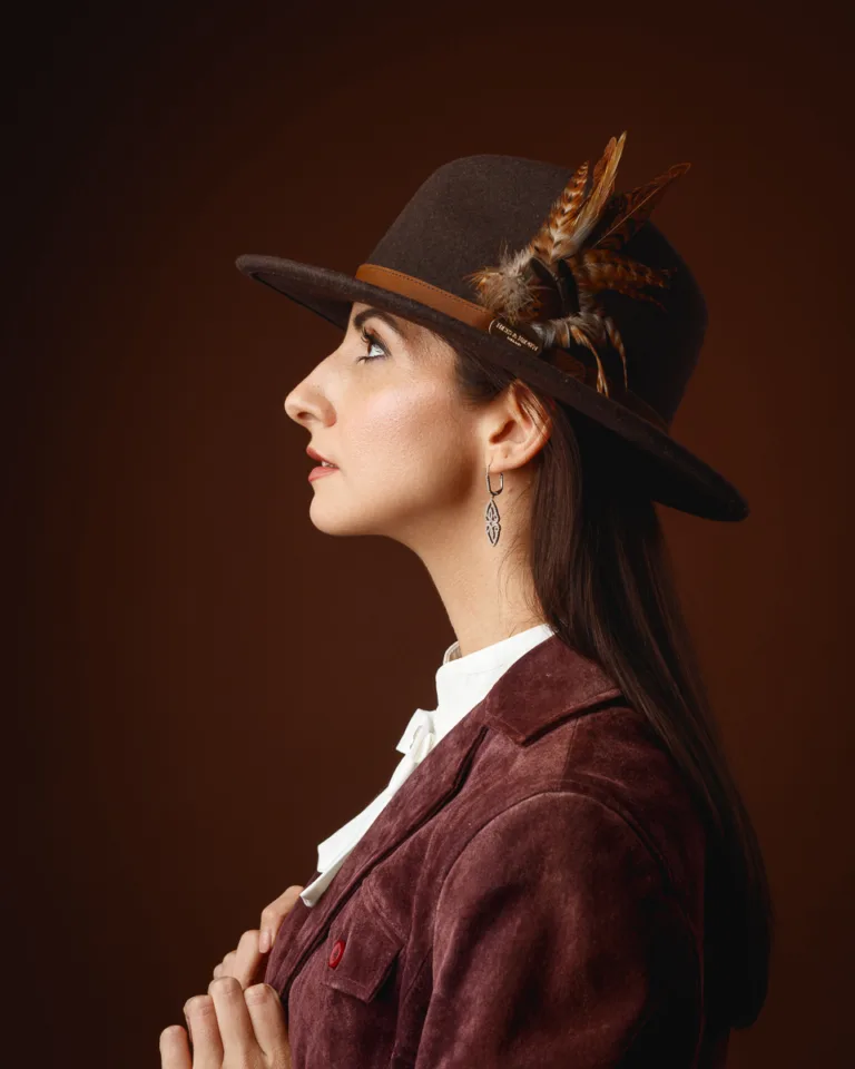 Woman in feathered hat and velvet jacket