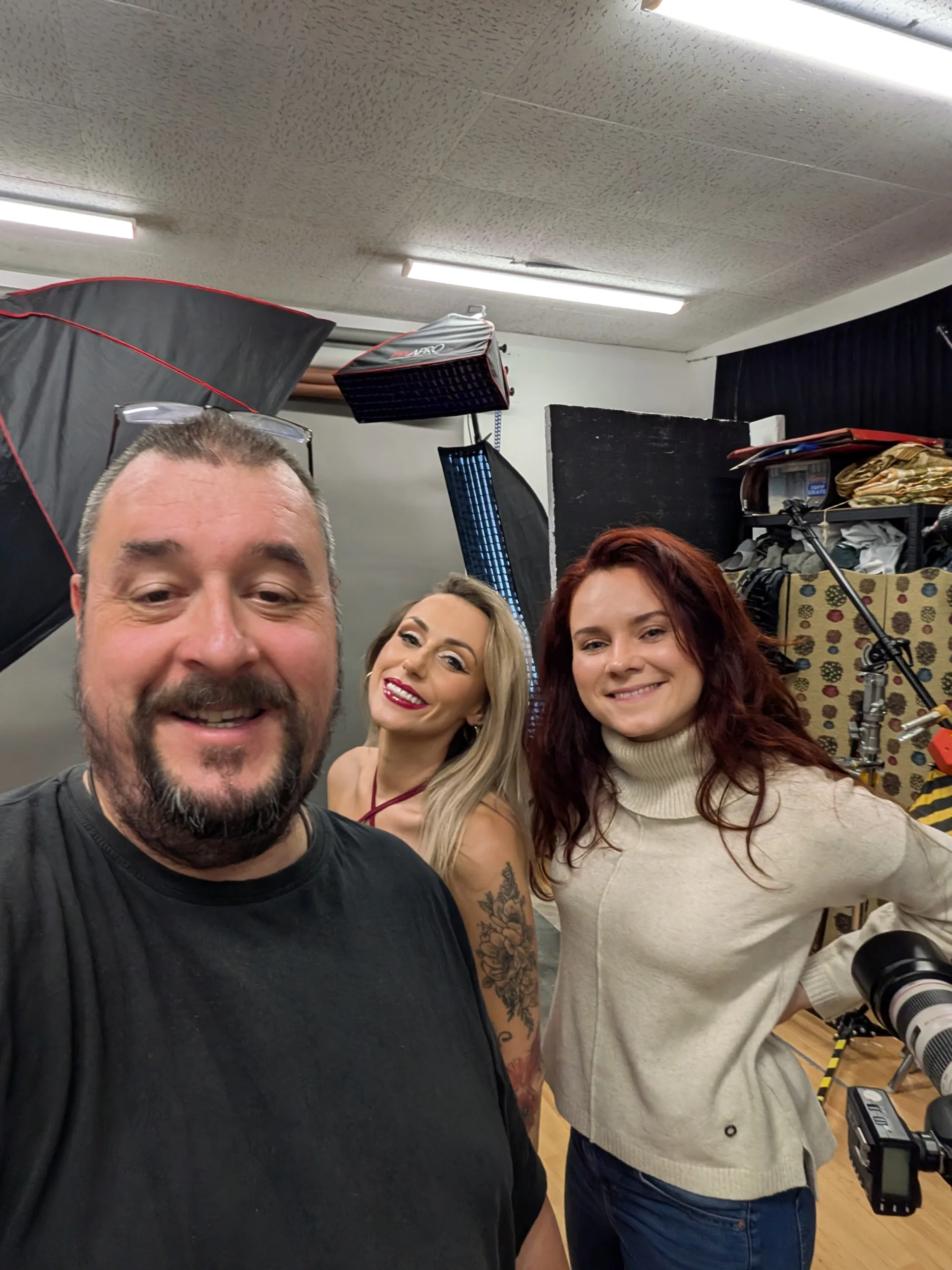 Three people smiling in a photography studio