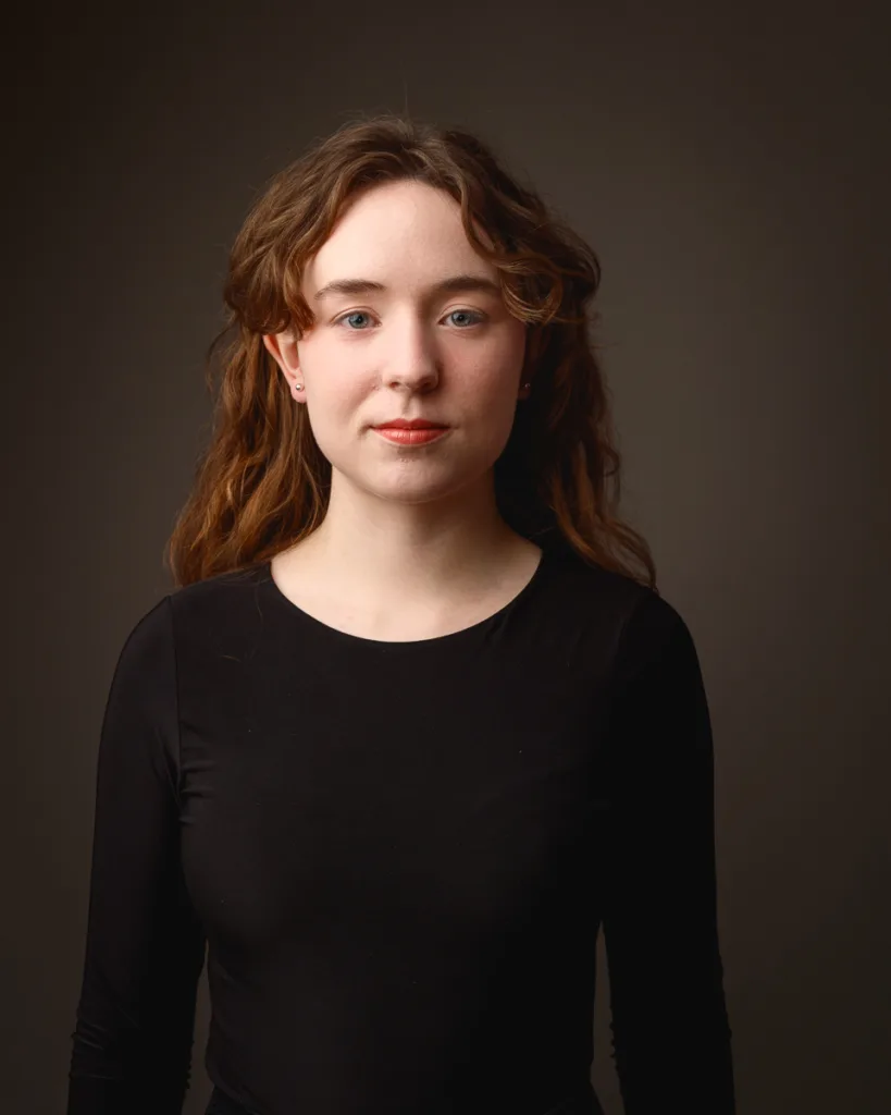 Woman with long hair wearing black top portrait
