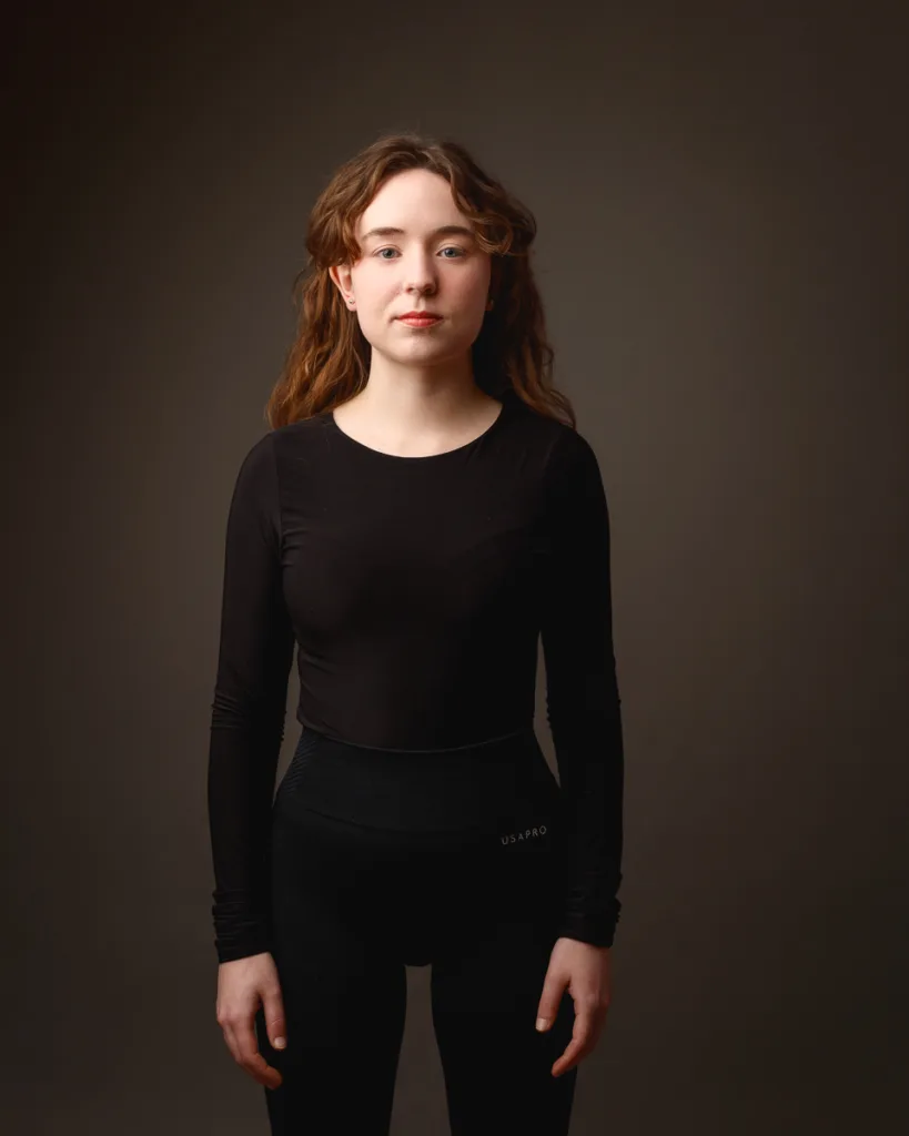 Woman wearing black outfit against dark background