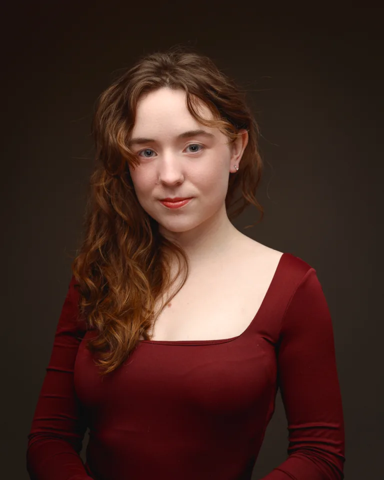 Woman wearing red dress against dark background