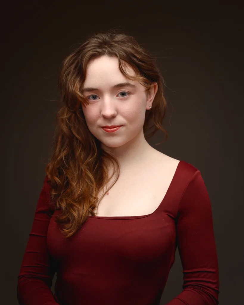 Woman wearing red dress against dark background