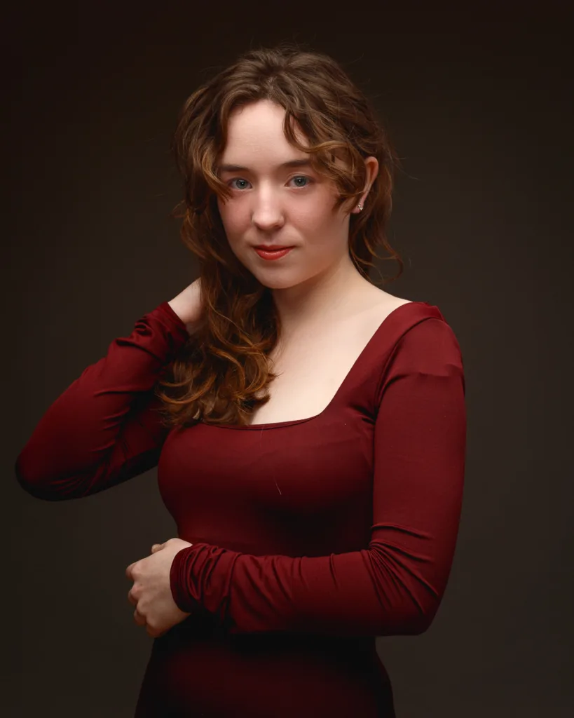 Woman posing confidently in a burgundy dress