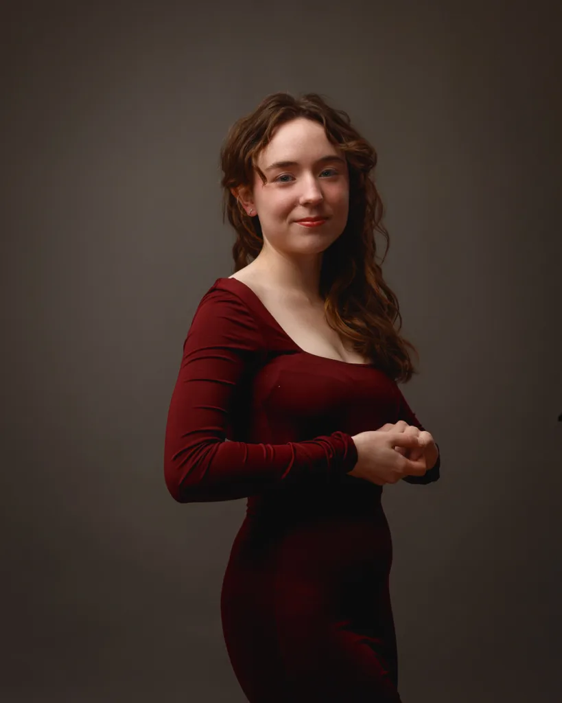 Person posing in elegant burgundy dress