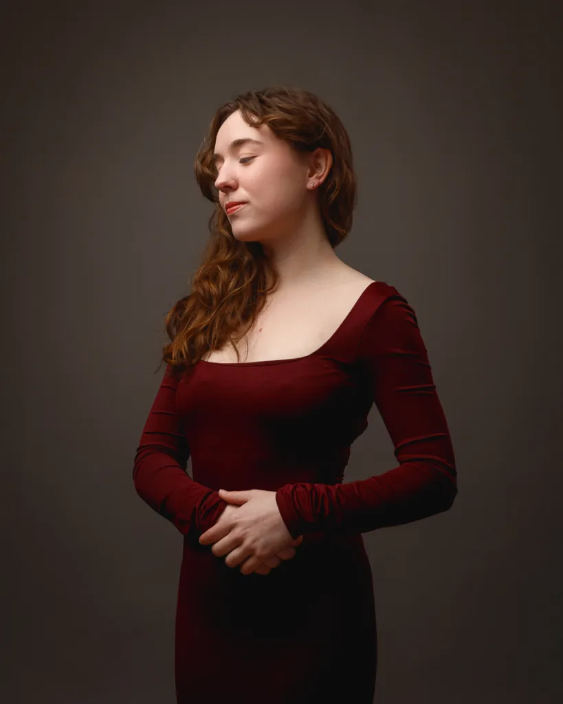 Woman in red dress posing against dark background